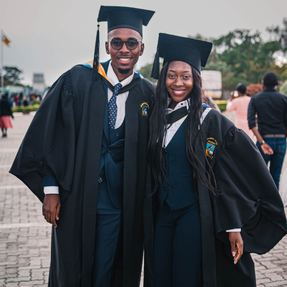 A Black man and woman in a graduation cap and gown.